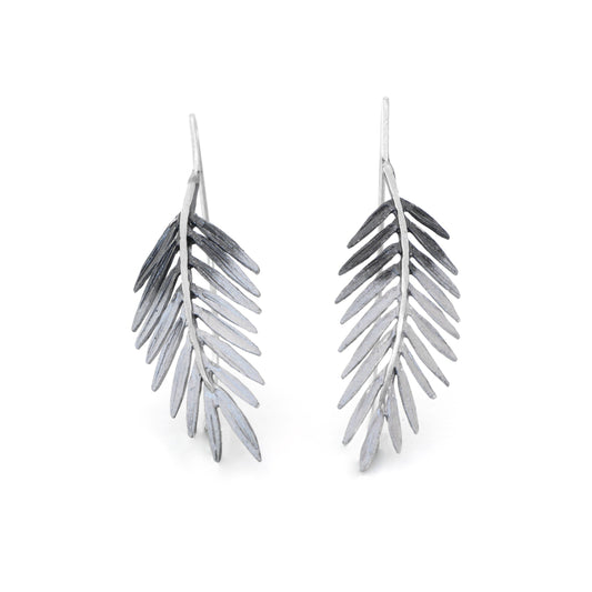 sterling silver palm tree earrings with a natural silver pigment and a hook backing by orfega compostela